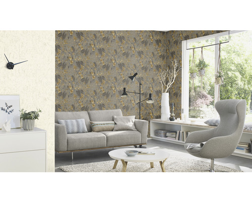 Salon lumineux avec canapé, fauteuil, table et papier peint à motifs pour une ambiance conviviale