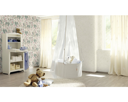 Chambre d''enfant lumineuse avec table à langer, panier suspendu avec voile et papier peint floral