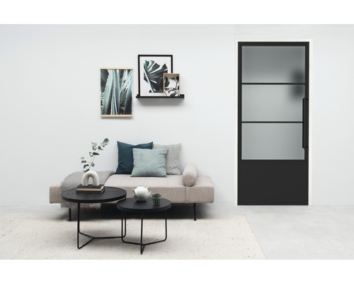 Salon avec canapé, tables basses et porte intérieure noire avec insert en verre