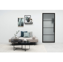 Salon lumineux avec lit de jour, tables basses et porte en acier