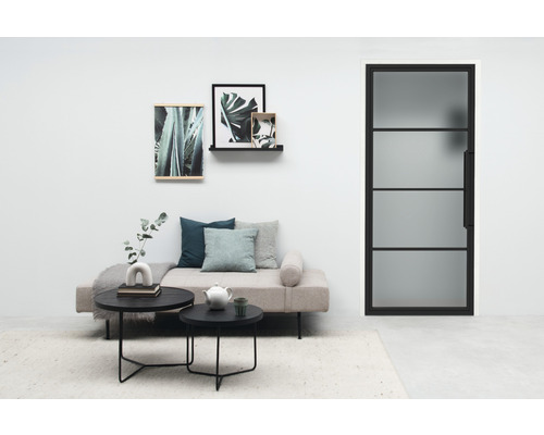 Salon lumineux avec lit de jour, tables basses et porte en acier