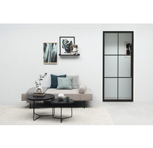 Salon avec lit de jour, tables basses, décoration murale et porte-fenêtre