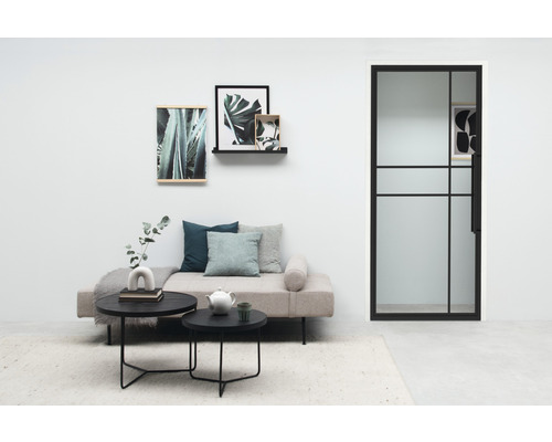 Salon avec canapé, table, décoration et une porte avec insert en verre