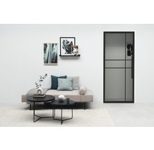 Salon avec canapé, tables basses, photos de plantes et porte en verre avec cadre