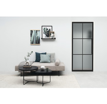 Salon avec canapé, tables basses, tableaux et porte intérieure avec insert en verre.