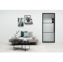 Salon lumineux avec canapé, tables basses, photos de plantes et porte en verre