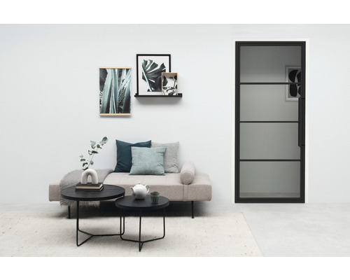 Salon avec canapé, tables basses, décoration murale et porte en verre