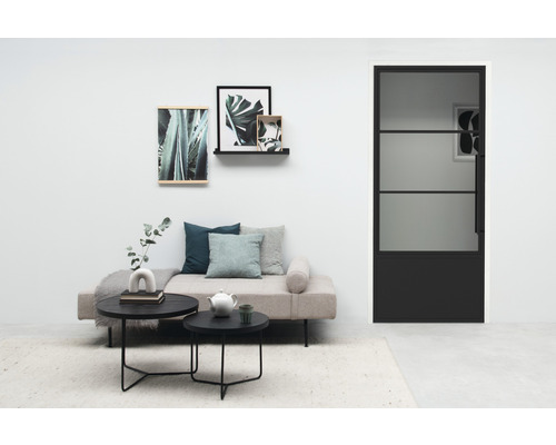 Salon avec canapé, tables basses, décoration murale et porte noire