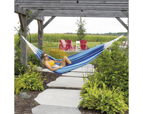 Frau entspannt in einer blau gestreiften Hängematte im Garten unter einer Holzpergola.