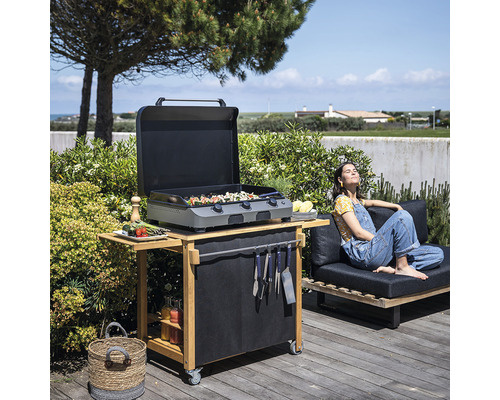 Scène de barbecue en plein air avec chariot de barbecue, grill et personne se détendant