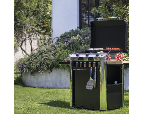 Chariot de grill avec couvercle ouvert, aliments grillés, épices et ustensiles de barbecue dans le jardin