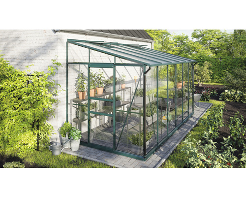 Gewächshaus aus Glas mit Pflanzen im Garten.