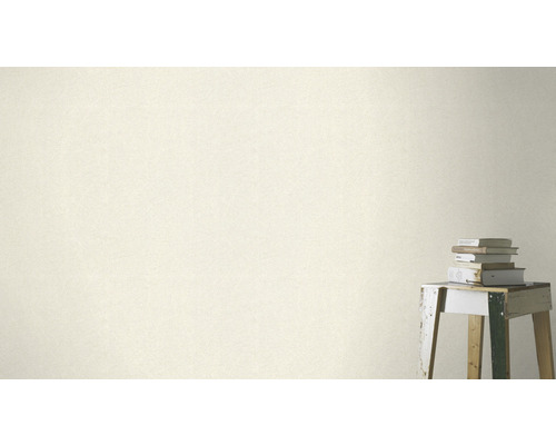 Gros plan d''un revêtement mural avec un motif subtil à côté d''une pile de livres sur un tabouret