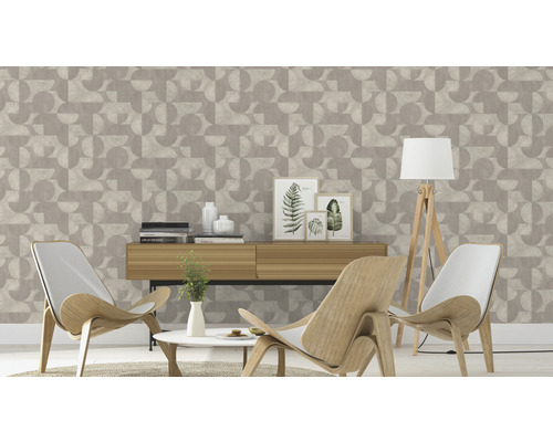 Salon décoratif avec papier peint géométrique, buffet, fauteuils et lampadaire