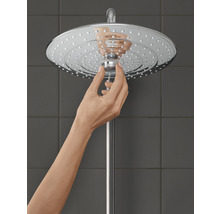 Une main ajuste la pomme de douche