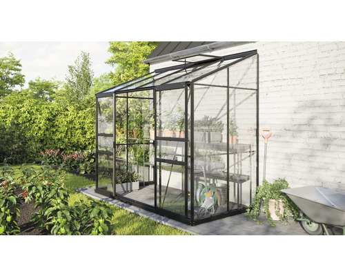 Serre en verre avec étagères et outils de jardin dans le jardin