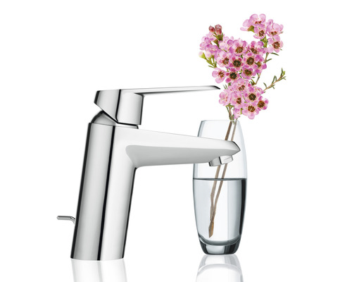 Robinet brillant à côté d''un vase de fleurs.