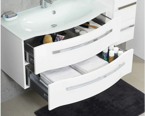 Meuble sous-lavabo avec tiroirs ouverts, équipé d''accessoires de salle de bain et de serviettes