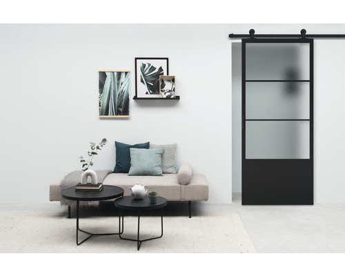 Salon avec porte coulissante, canapé, table basse et décoration murale