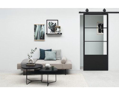 Salon avec porte coulissante, canapé, tables basses et décoration murale pour une ambiance élégante