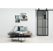 Salon avec lit de jour, table basse et porte coulissante de style industriel