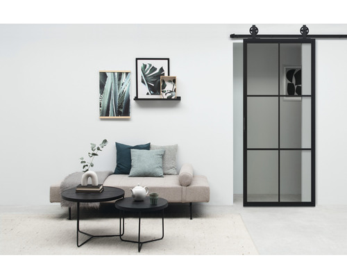 Salon avec lit de jour, table basse et porte coulissante de style industriel