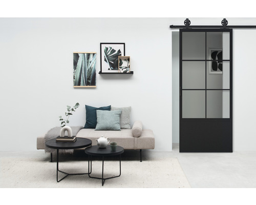 Salon avec lit de jour, tables basses et porte coulissante en verre