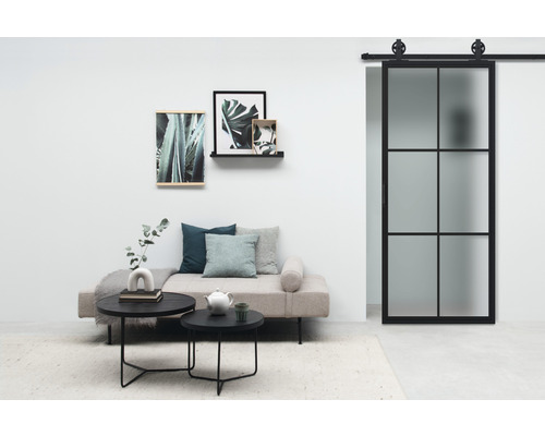 Salon avec lit de jour, table basse et porte coulissante avec cadre en acier et verre dépoli