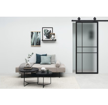 Salon avec lit de jour, tables basses, décoration et porte coulissante avec cadre en acier