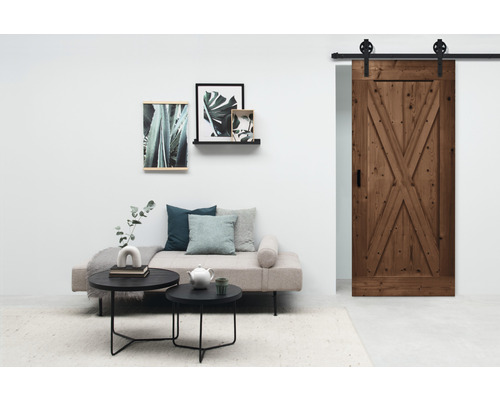 Wohnzimmer mit Couch, Tischen, Dekoration und Holztür mit Beschlägen
