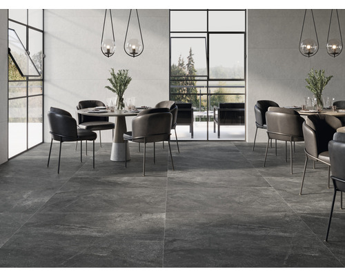 Intérieur avec carrelage de sol foncé, tables à manger et chaises.