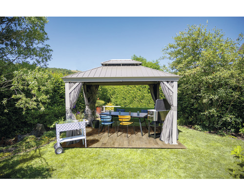 Jardin avec pavillon, table à manger, chaises, barbecue et chariot à plantes sur pelouse