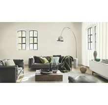 Helles Wohnzimmer mit Ledersofa, Holztisch und grossen Fenstern.