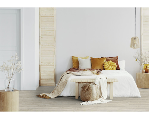 Helles Schlafzimmer mit Bett, Kissen, Decke und Holzboden