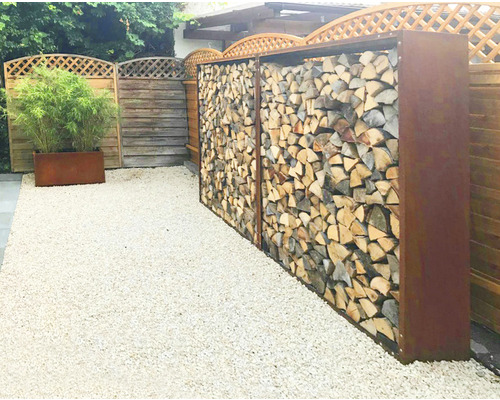 Gartenbereich mit Holzlager in Rostoptik und Kiesboden
