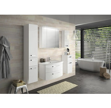Salle de bain moderne avec meubles blancs, baignoire et stores de fenêtre.