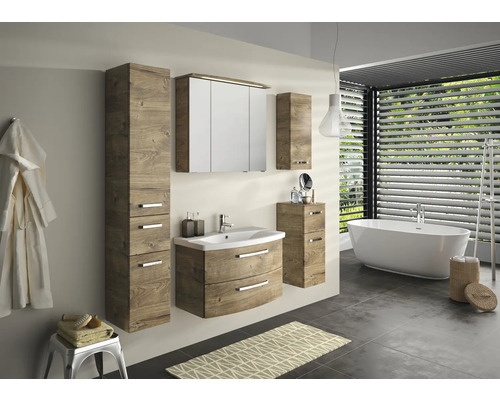 Salle de bains avec lavabo, armoire de toilette, armoire haute et baignoire dans une ambiance claire et conviviale.