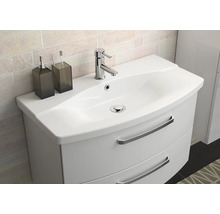 Meuble sous-vasque avec lavabo, robinetterie et accessoires de salle de bain pour une salle de bain bien rangée.
