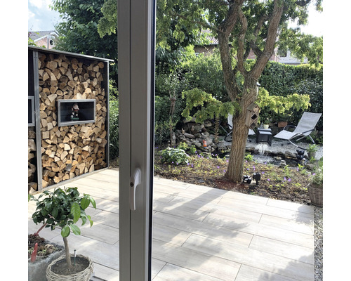 Vue du jardin avec étagère à bois, bassin et mobilier de jardin