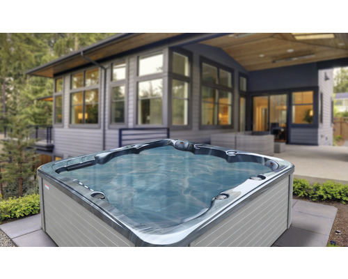 Quadratischer Whirlpool im Garten vor einem Haus