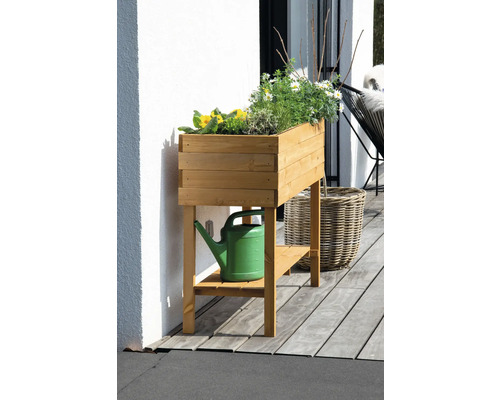 Jardinière sur pieds en bois avec des plantes et un arrosoir