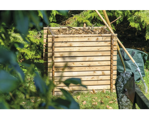 Composteur en bois dans le jardin avec outils de jardinage