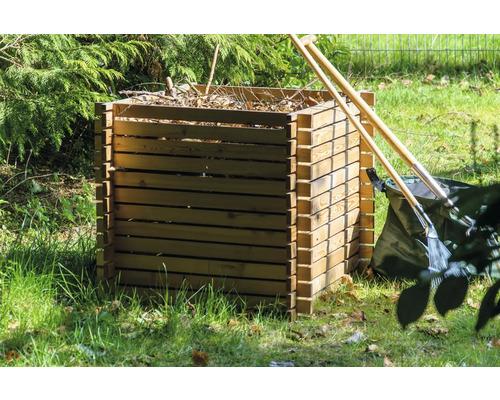 Composteur en bois dans le jardin avec outils de jardinage