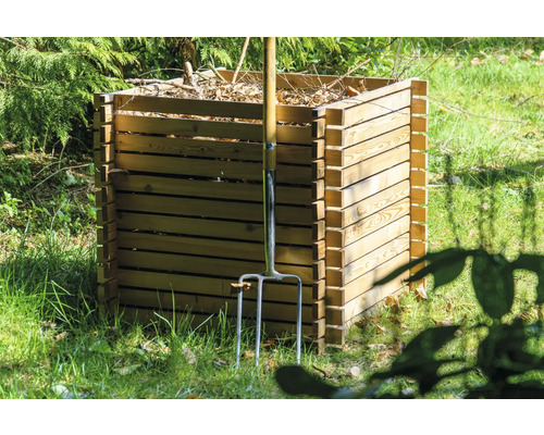 Composteur en bois dans le jardin avec une fourche