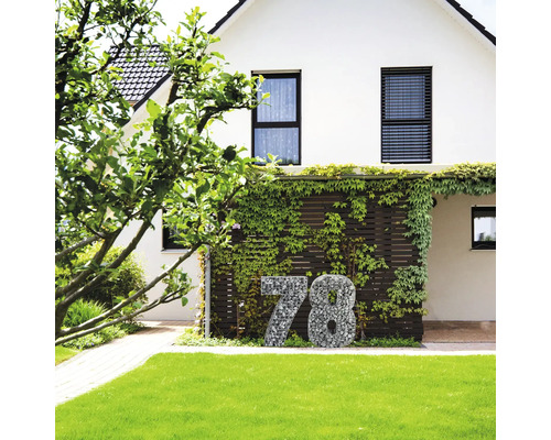 Façade de maison avec numéro de maison en gabions devant un espace vert