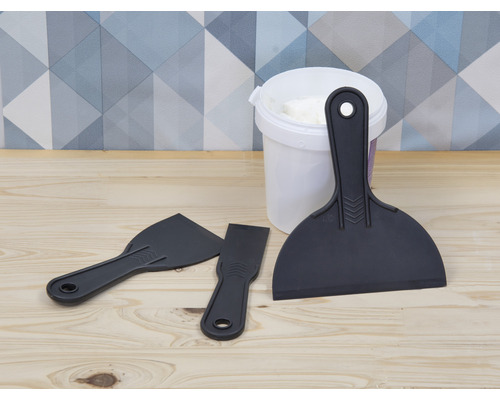 Mastic dans un seau avec trois spatules en plastique