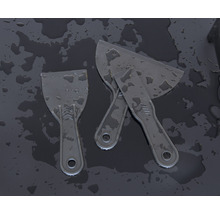 Trois spatules en plastique sur fond sombre