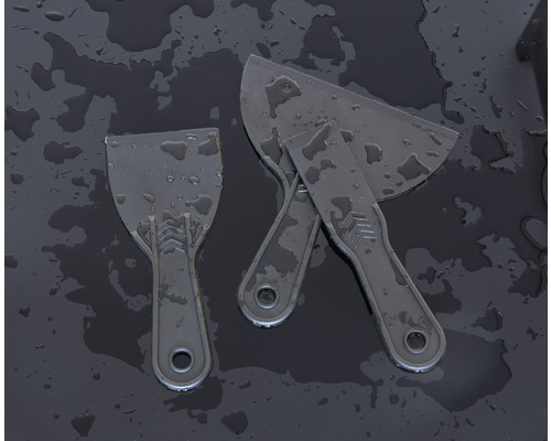 Trois spatules en plastique sur fond sombre