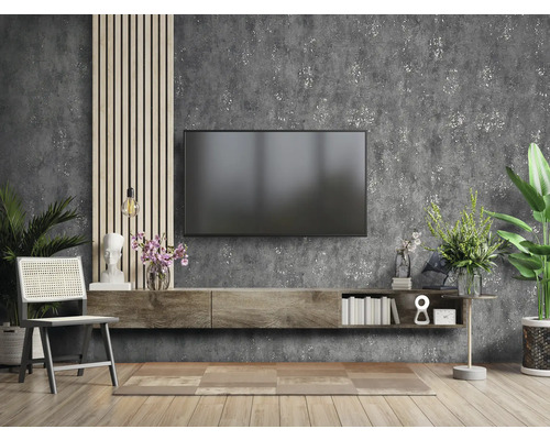 Salon avec télévision, meuble bas, chaise et décorations devant un mur texturé