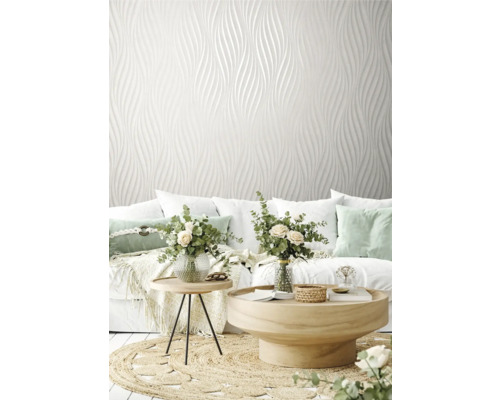 Salon avec papier peint design blanc, canapé et tables en bois sur un tapis